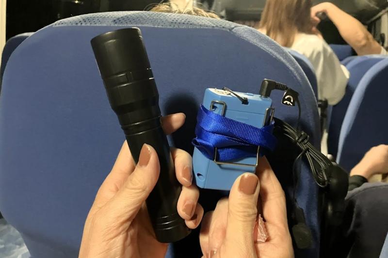 移動の車内で、ペンライトとイヤホン付きのワイヤレスガイドシステムの機器が配られました。