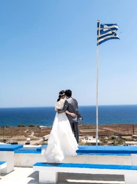 サントリーニ島でのウェディングフォト。ポアビーチ近くのブルードームの建物にて