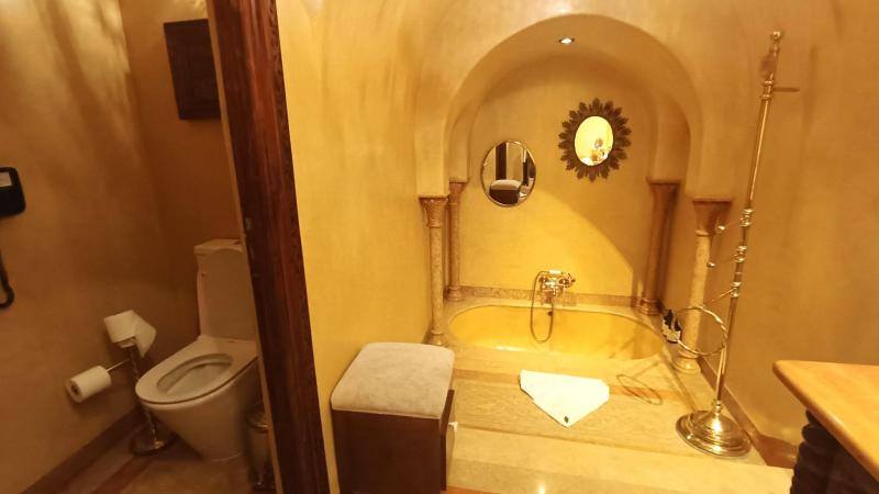 ゴールドのバスタブと快適なバスルーム