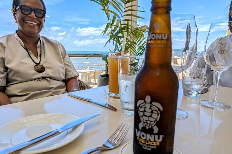 フィジーの人気ビール「ボヌ（VONU）」と、奥でほほ笑んでいるのは今回ご案内してくださった、ホテルのセールス担当のVIKAさんです。VIKAさんは、阪神淡路大震災の前まで日本で日本語を学んでいたそうで、簡単なコミュニケーションなら日本語でも可能でした！ 日本人ゲストのことも理解してくれて、いざというときも安心ですね。