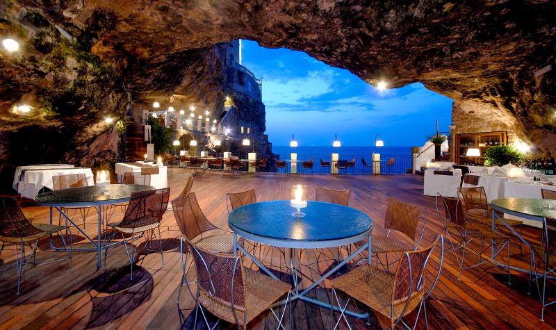 【ホテル リストランテ グロッタ パラッツェーゼ（イタリア）】イタリアのバーリ空港から車で約40分。長靴型のイタリアのかかとのあたりに位置するポリニャーノ・アマーレは、アドリア海の真っ青な海とそそり立つような崖が入り組んだ風光明媚なリゾート地です。海を見下ろす崖の上に建つ5つ星の「ホテル リストランテ グロッタ パラッツェーゼ（Hotel Ristorante Grotta Palazzese）」の魅力は、崖の中州の洞窟を利用した絶景のレストラン。暖色系のライトの元、ロマンティックな時間が流れていきます。