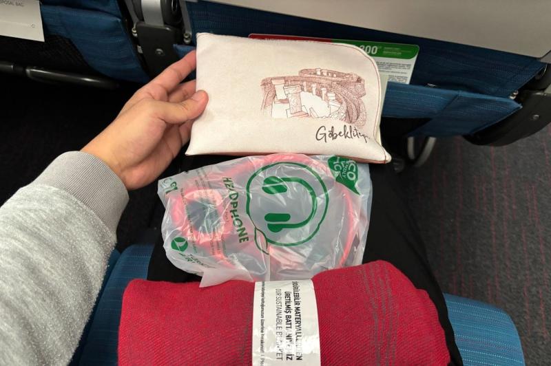 アメニティーには、イヤホンやスリッパ、ブランケットに加え、クッション（ネックピロー）も