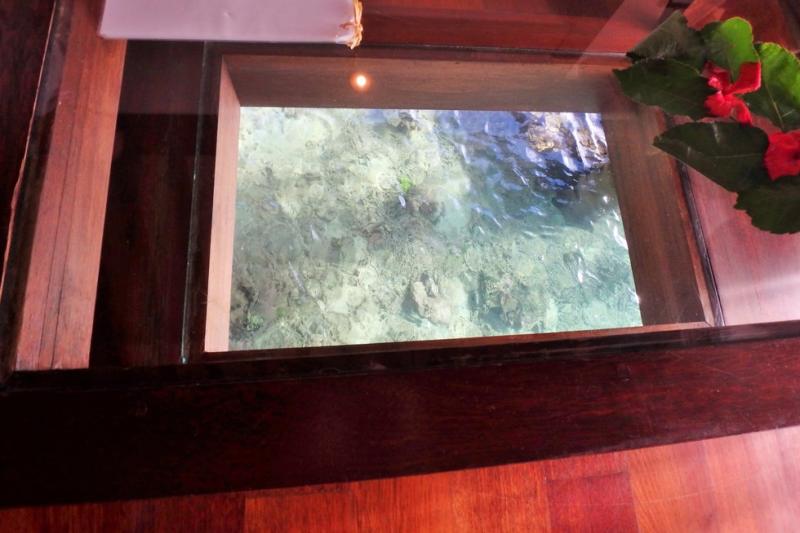 水上バンガロー客室内にあるガラスパネル。そこから水中をのぞいてみるとサンゴ礁が見えて魚も見えました。