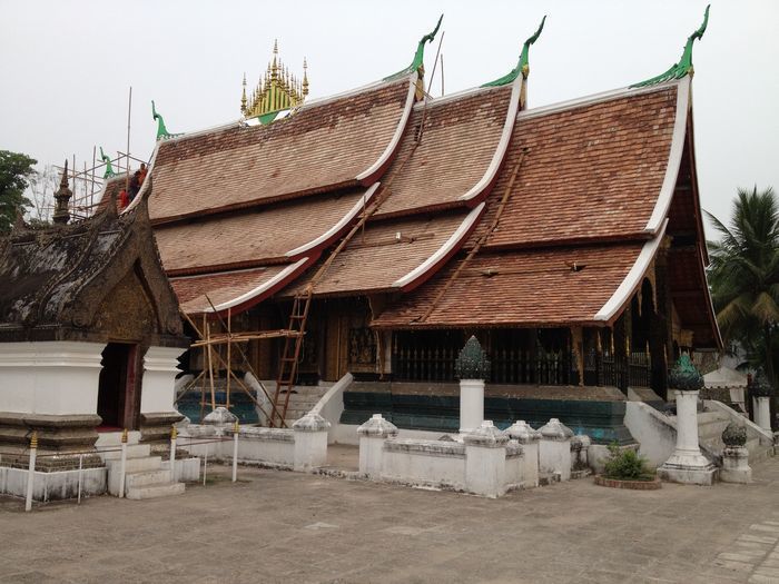 「ワットシェントーン」最古の寺院／三重の屋根が特徴的。よく見ると僧侶が屋根の修復作業をしていました。