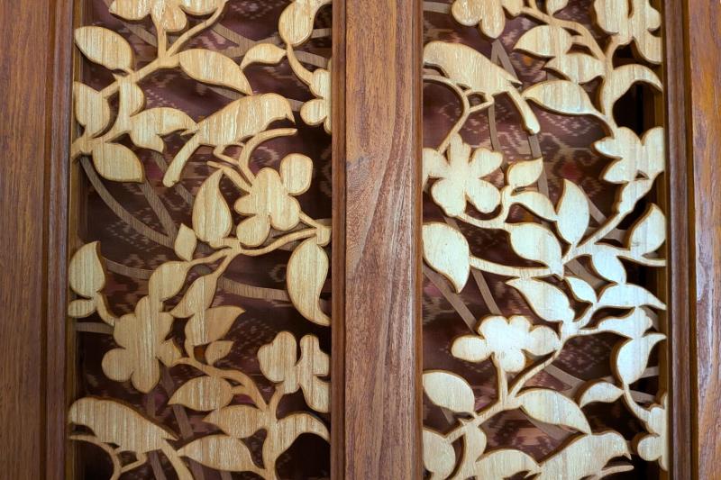 ベッドのヘッドボードに施された美しい木の装飾にバリらしさを感じます