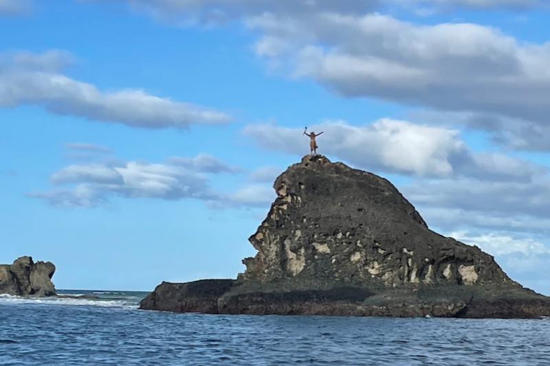 もうすぐ到着という頃、リゾート近くの海上にそびえ立つ岩の上で、リゾートのスタッフがなんと歓迎の舞を踊って出迎えてくれました！ ワクワクと冒険心が掻き立てられます！