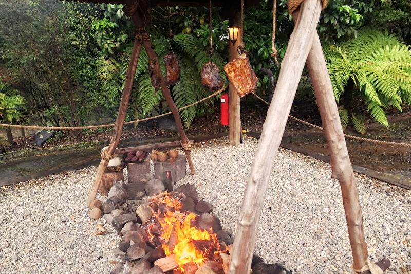 吊るしたお肉を焚き火で焼き上げます