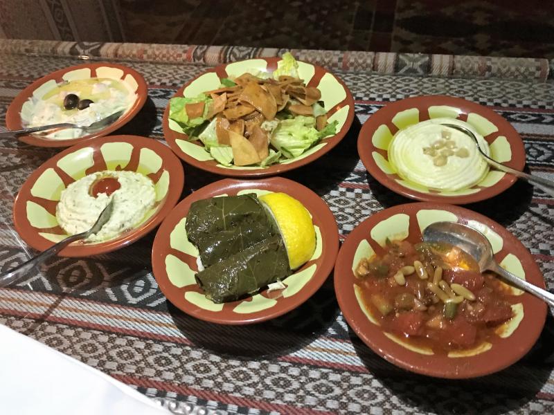 メゼと呼ばれるアラブ料理の前菜。フムス、ファトゥーシュという名のサラダ、野菜の煮込み、甘めのペーストなどどれも美味です