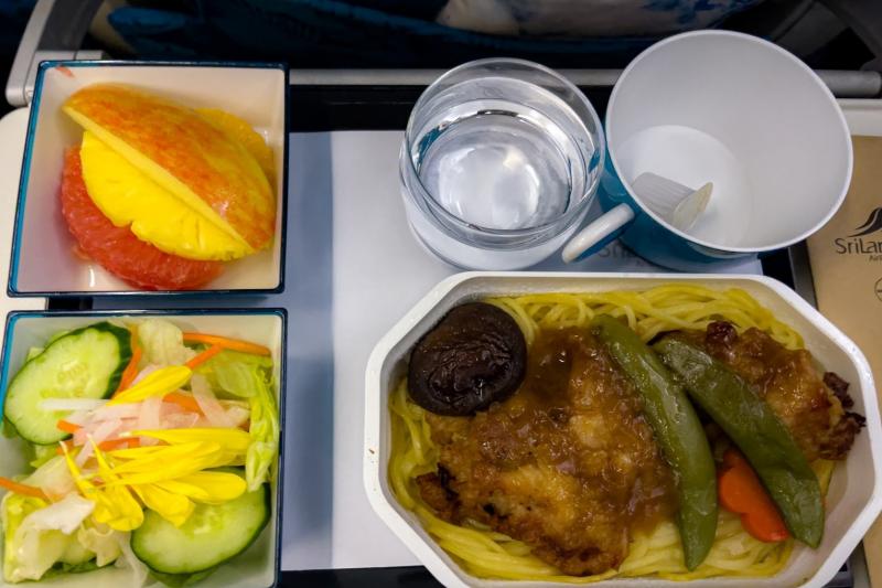 夕食はフィッシュかチキンから選択。今回はチキンを選びました。甘辛な味付けで、下に添えられた炒め麺（焼きそば風）との相性も抜群。サラダはシャキシャキのサウザンドレッシングがかかっており、フルーツも甘く新鮮です。