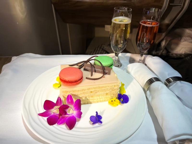 エミレーツでも新婚旅行をお祝いしてもらいました。ハネムーンのお祝いケーキとシャンパンをドバイ→関西の復路の区間で提供されました。シャンパンはロゼと白で、ケーキも美味しかったです（写真の右はロゼのシャンパンです）！ 手配頂き、ありがとうございました(^^)余談ですが、経由地のドバイの空港が広すぎて迂闊にウロウロできませんでした（笑）。