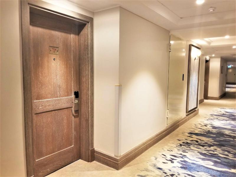 お部屋の前に、ホテル内の廊下とドアです。水色を基調とした廊下と木目調のドアにセンスの良さを感じました