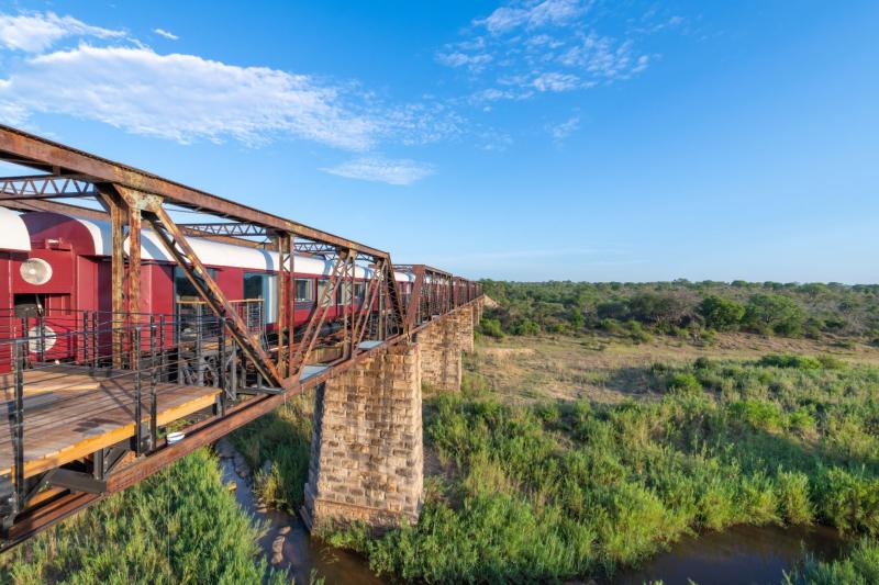 クルーガー シャラティ（南アフリカ）2020年12月、クルーガー国立公園内にオープンしたのは、廃線となった鉄橋の上に停まる電車をホテルとしてよみがえらせたラグジュアリーサファリホテル。車両を改装した24室あるキャリッジルームは、電車の中とは思えないほど、ラグジュアリーで贅沢な空間です。大きなガラス窓からは遮ることのない絶景も望めます。《❷・❽》