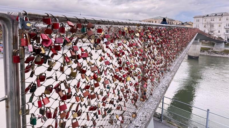 城塞の麓に広がる旧市街へ降りていくと、ザルツァッハ川には旧市街と対岸を結ぶ橋が架かっています。マカルト橋は、恋人たちが南京錠をかけることで有名な人気スポットで、パリのポン デ ザールを思わせる雰囲気があります。