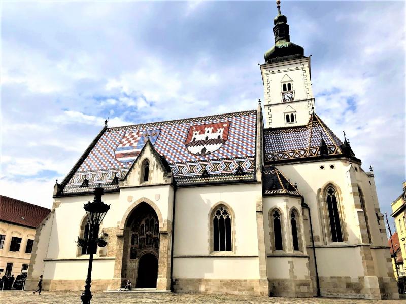 赤と青のモザイク模様の屋根が印象的なかわいらしい屋根瓦が印象的な聖マルコ教会