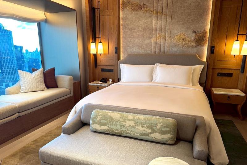 こちらはベッドが窓に対して平行に配置されているお部屋。ベッドの端にもソファを配置