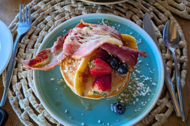 朝食のパンケーキにベーコンをトッピング。トッピングは豊富に選べます